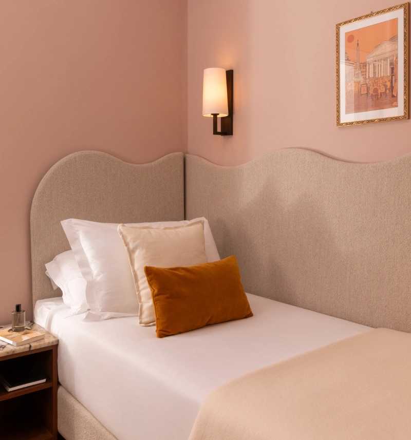 Camera singola con testiera imbottita ondulata, pareti rosa cipria e cuscino ocra, comfort nel centro di Roma vicino ai Fori Imperiali - Hotel Fori Imperiali, BZAR hotels a Roma