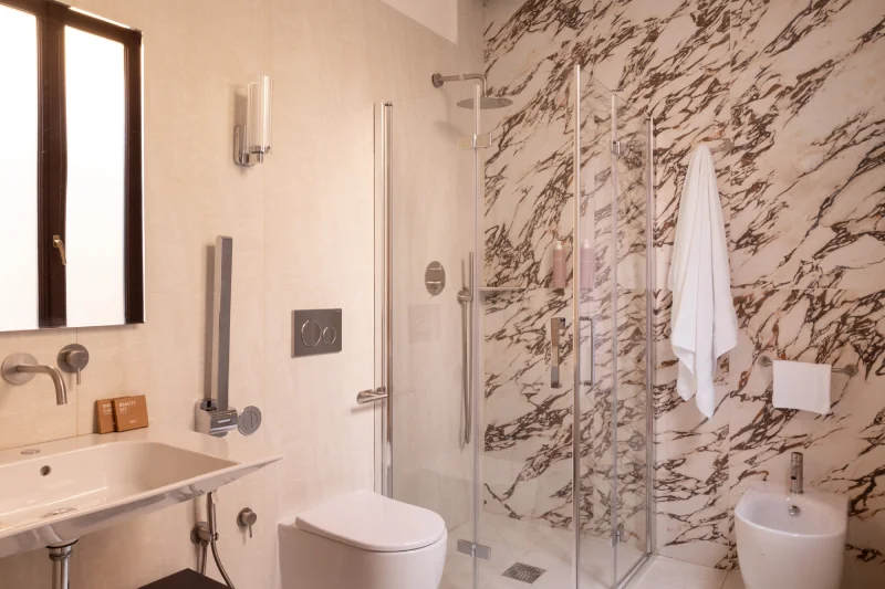 Bagno moderno della camera tripla con doccia walk-in, rivestimenti in marmo e design contemporaneo vicino ai Fori Imperiali - Hotel Fori Imperiali, BZAR hotels a Roma